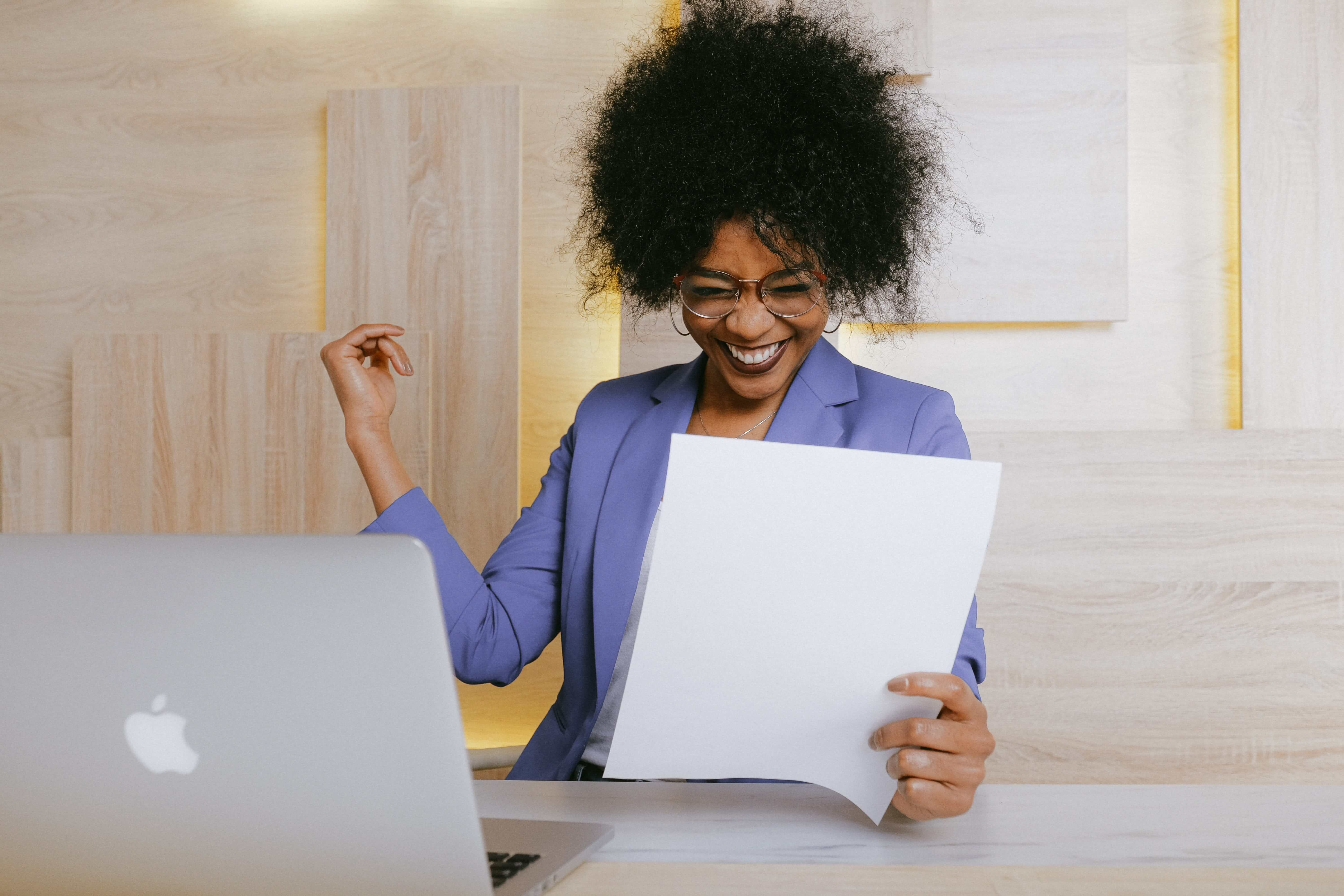 A woman smiling and holding a piece of paper