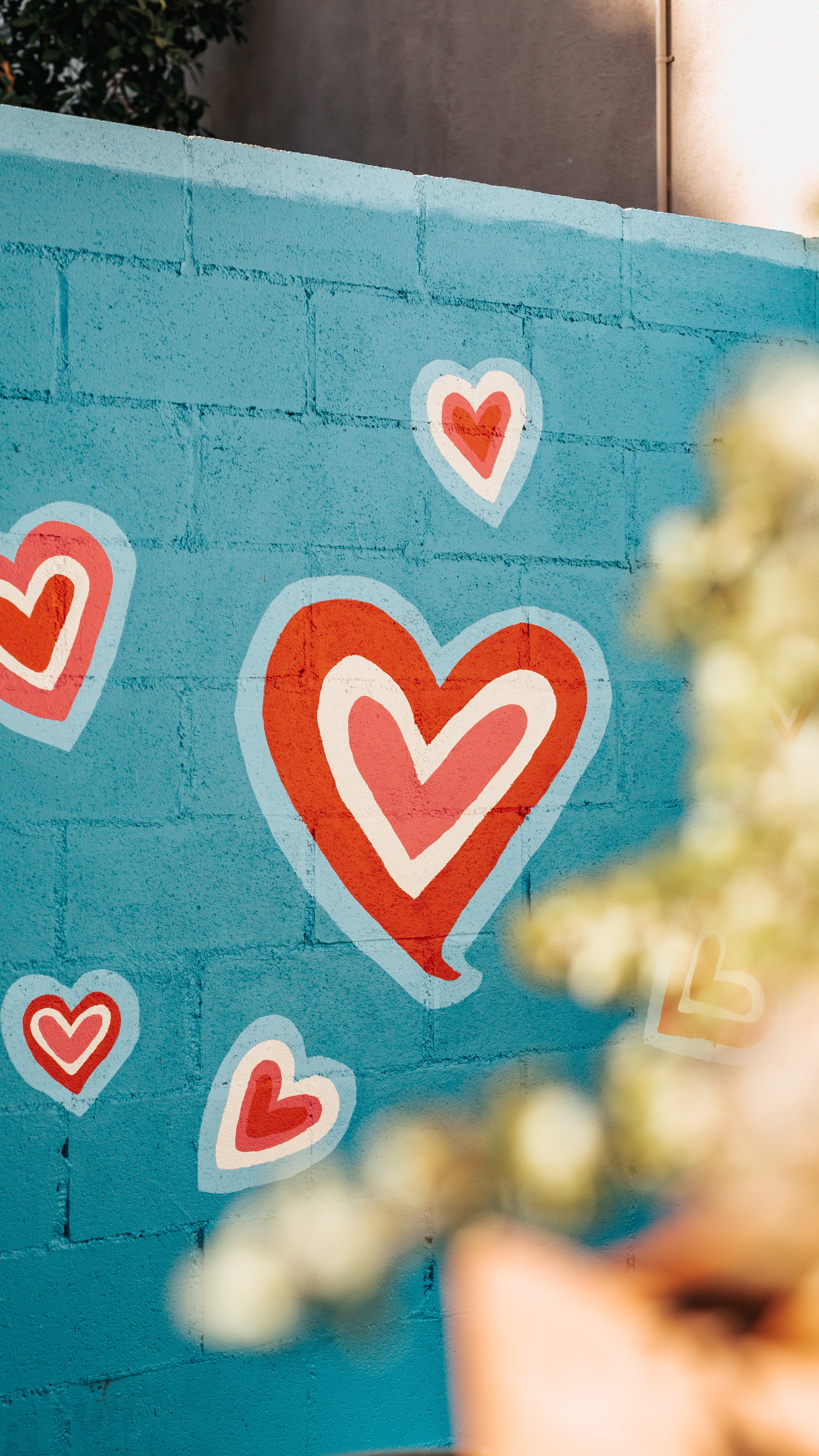 Painting of a heart on a blue brick wall