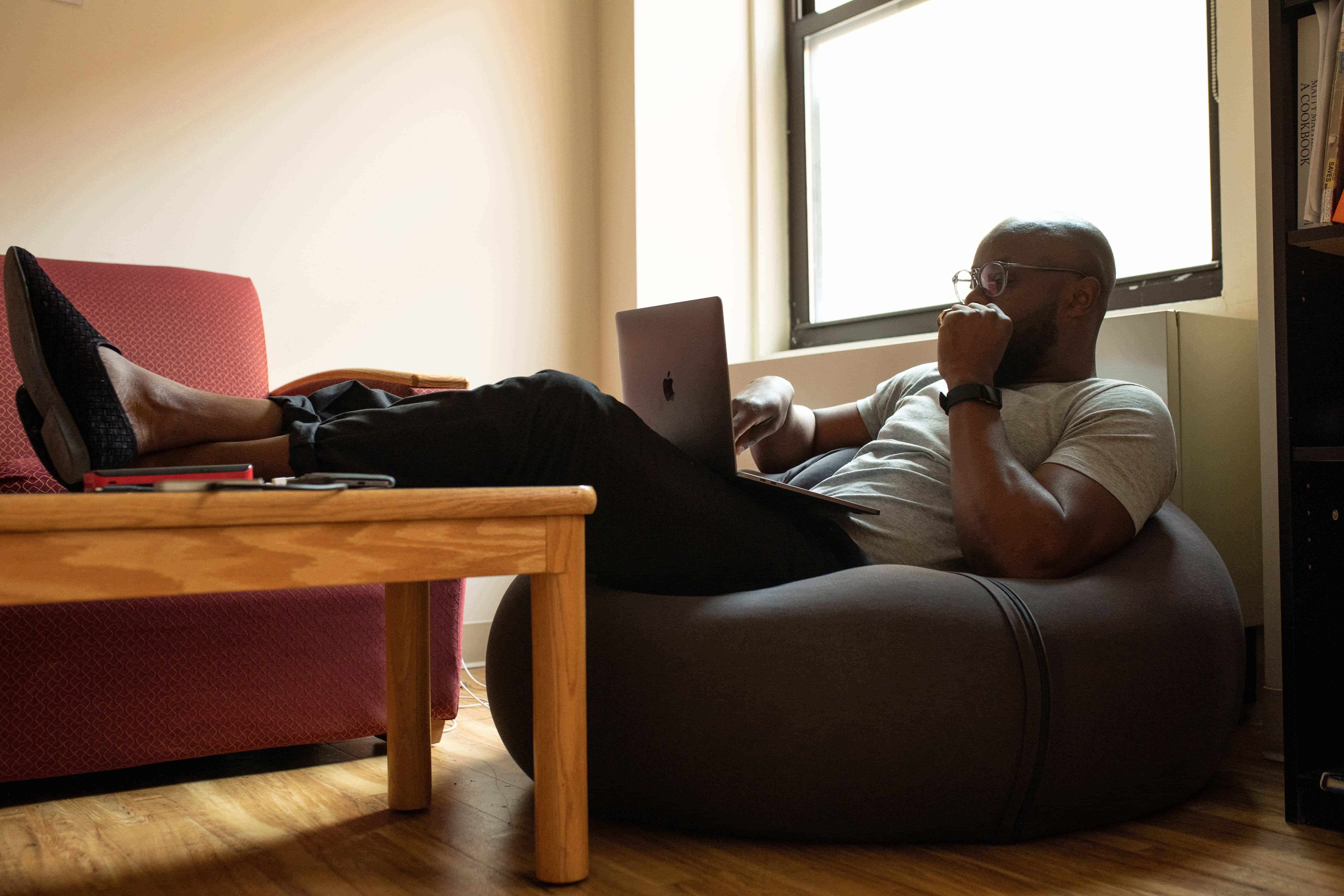 man sitting on a beanbag with laptop