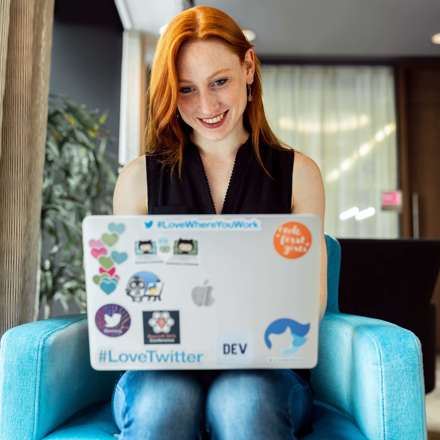 Woman Smiling and Sitting On Blue Sofa Chair