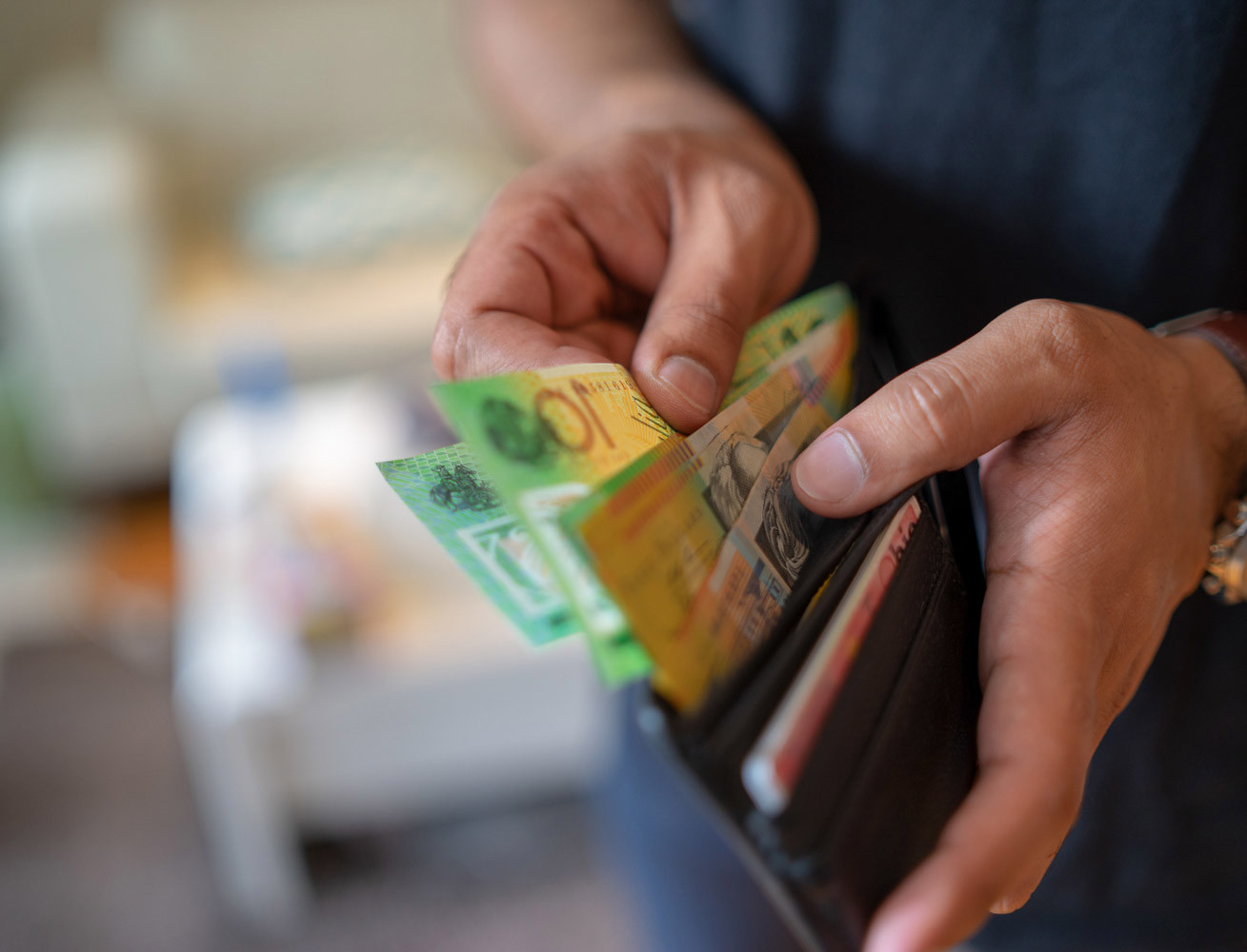 A male taking money out of the valet.