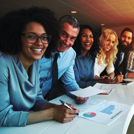 Cheerful multiracial colleagues looking at camera in office.