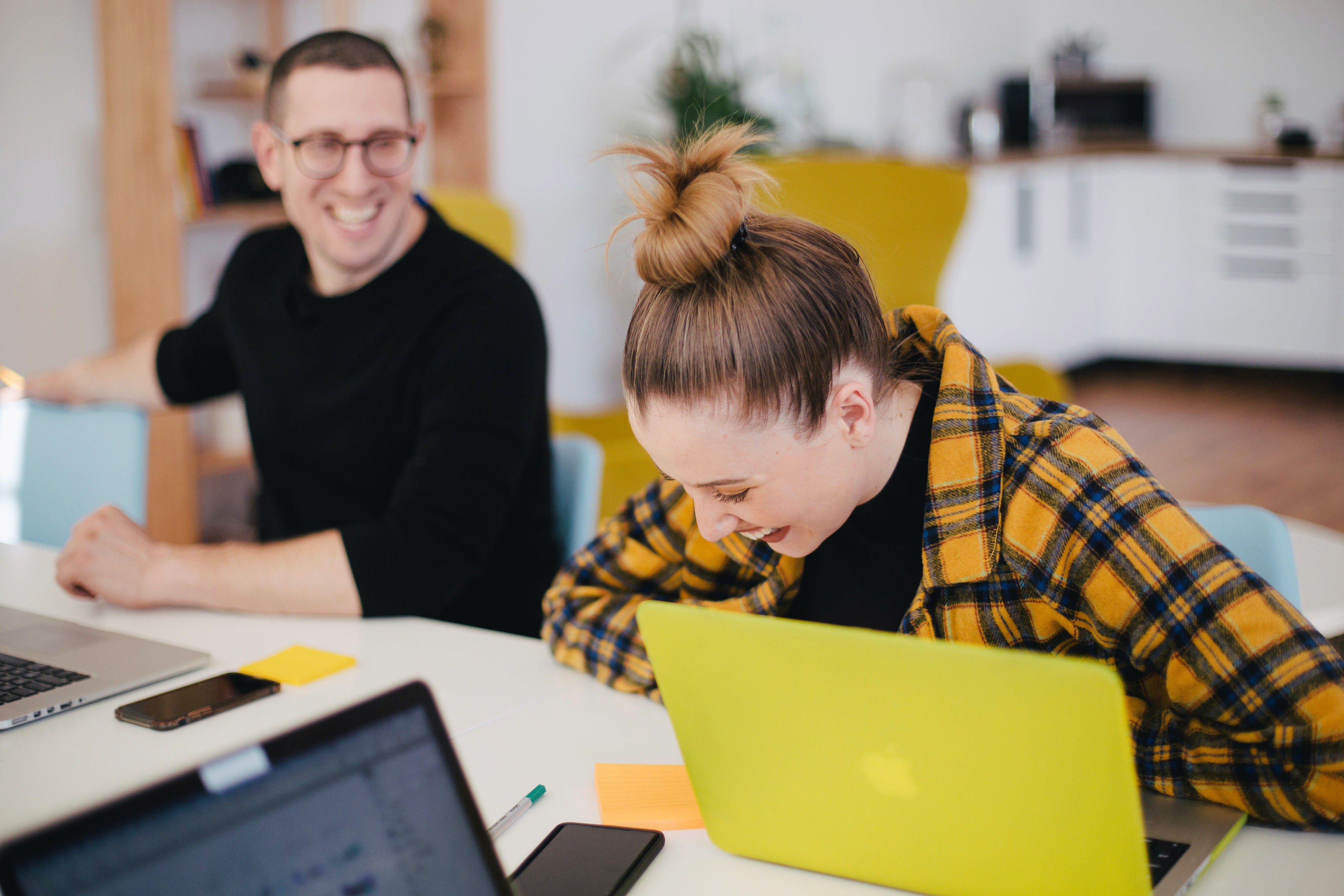 A man and woman laughing in an office