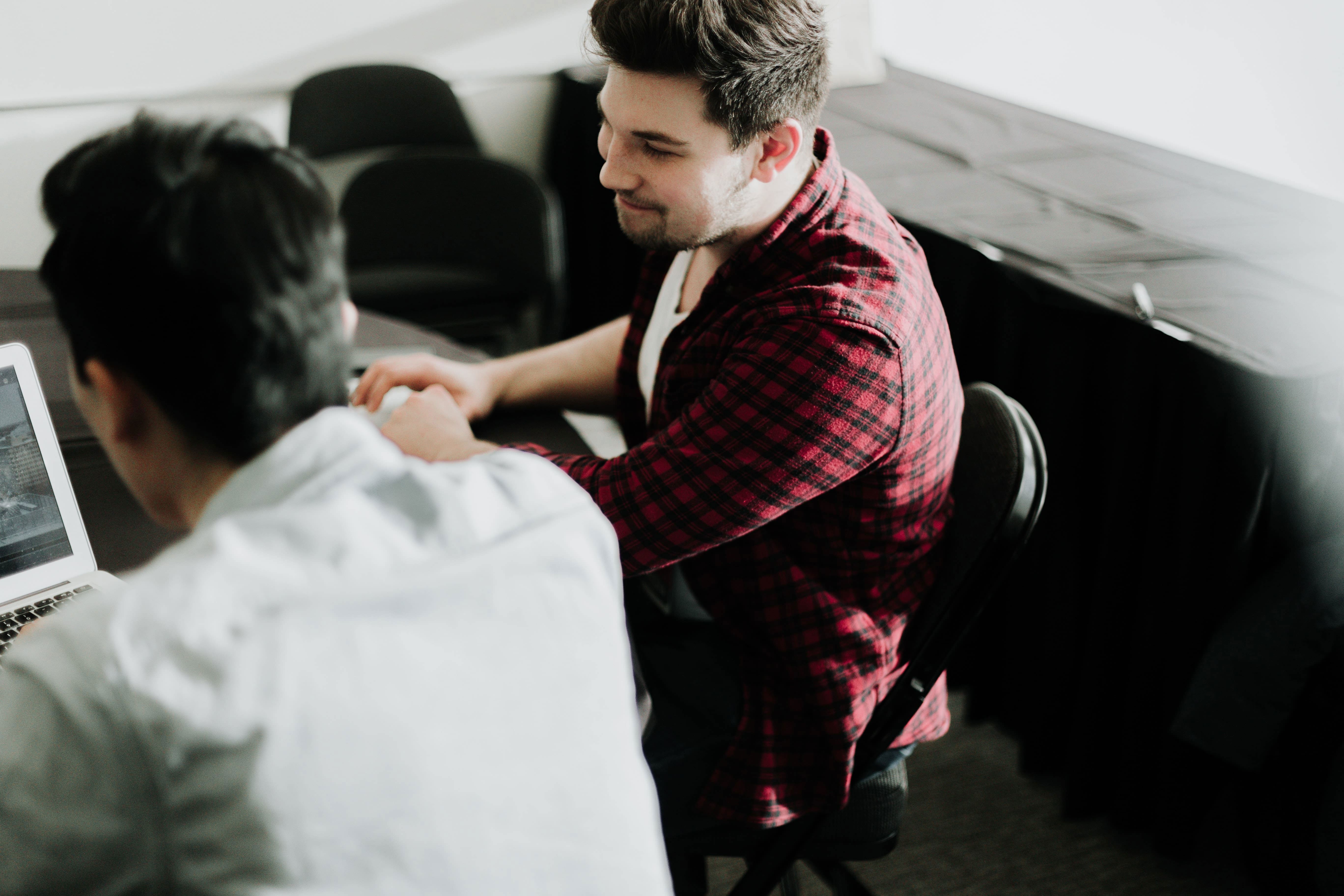 Two men sitting next to each other in an office