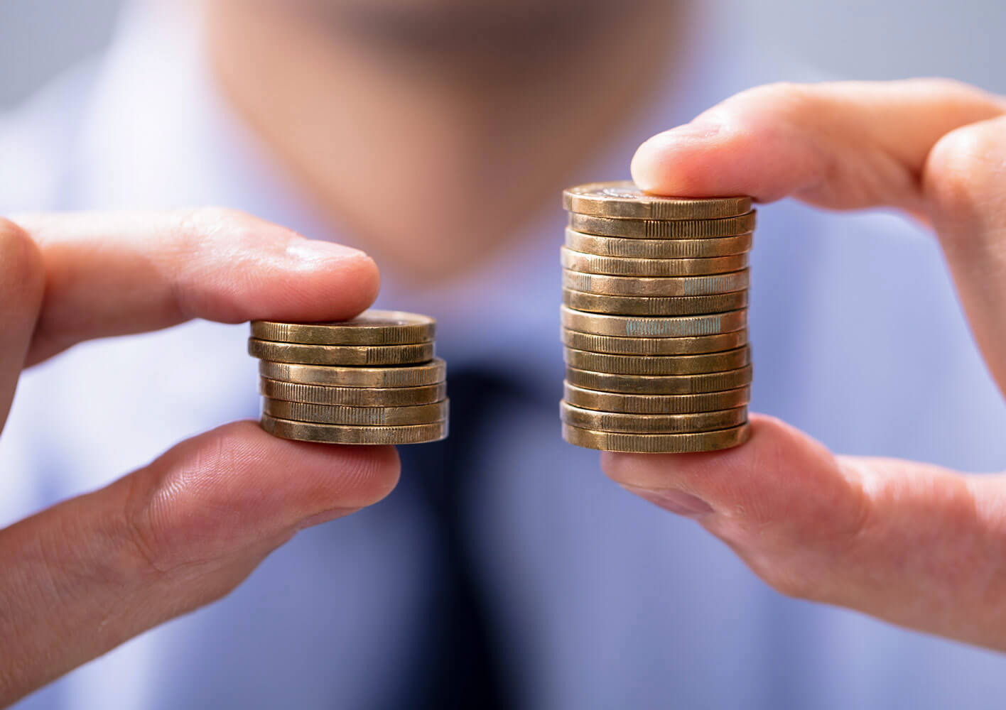 Man comparing two coin stacks