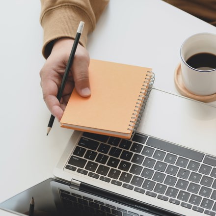 Person Holding White Ceramic Mug Beside Laptop