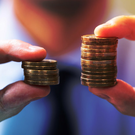 Man Comparing Two Coin Stacks