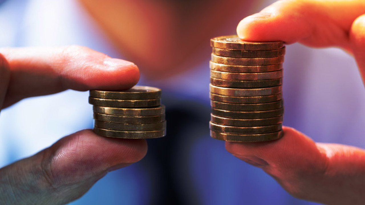 Man Comparing Two Coin Stacks