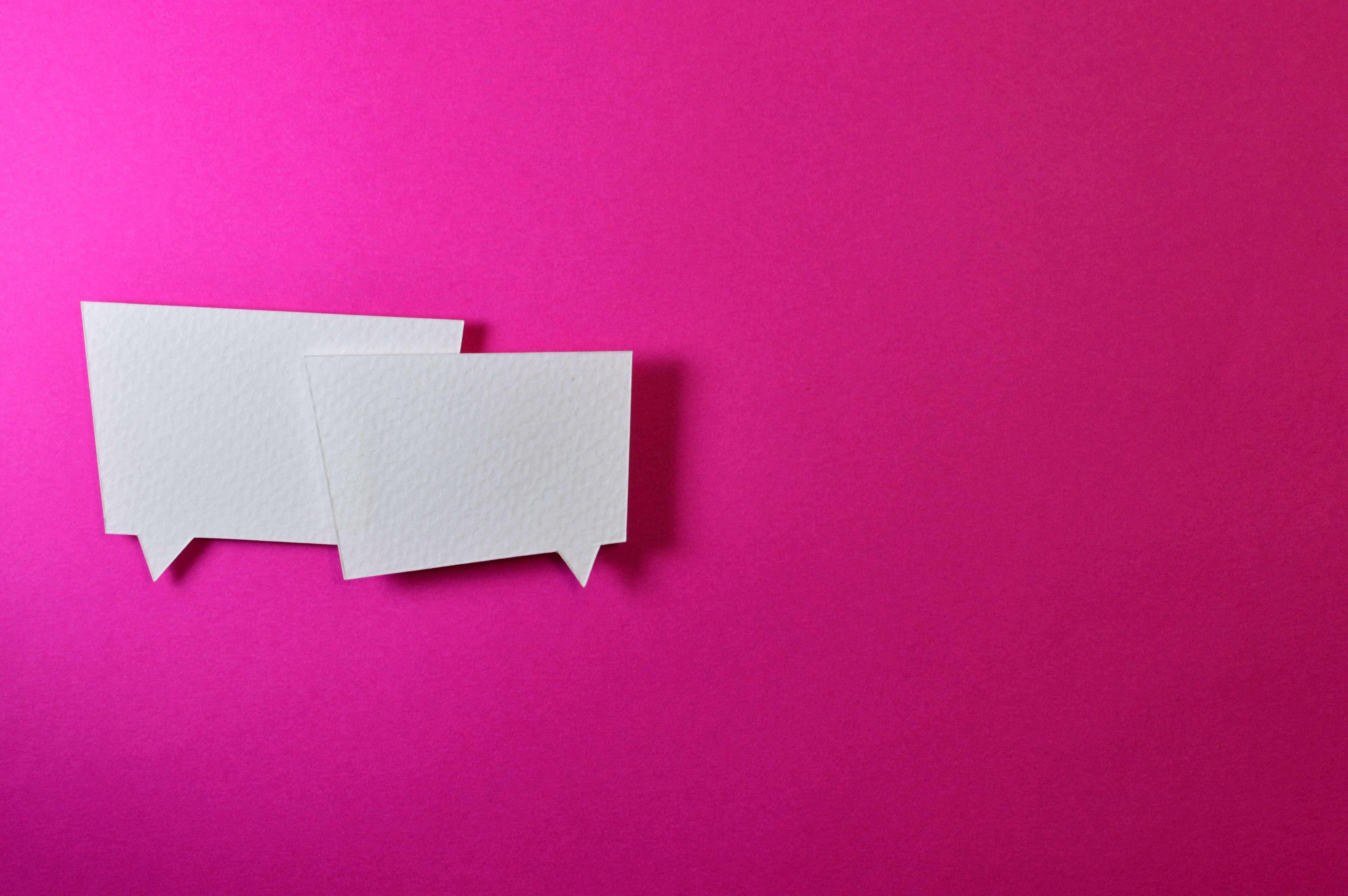 Two White Message Balloons on a pink background